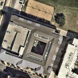 Four beach volleyball courts. Nets are hung between the light poles. — aerial view